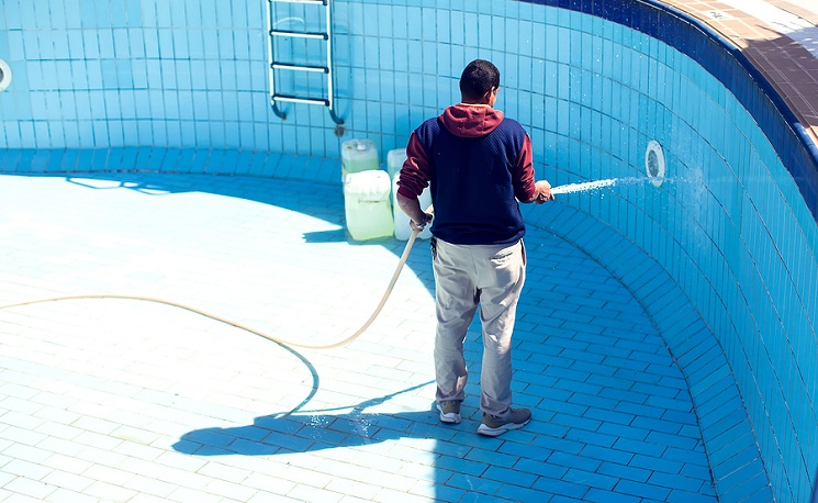 Service And Maintenance Of The Pool. Man Cleans The Pool.